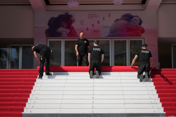 Crew members install the red carpet at the Palais des Festivals ahead of the opening ceremony of the 78th international film festival, Cannes, southern France, Tuesday, May 13, 2025. (Photo by Lewis Joly/Invision/AP)