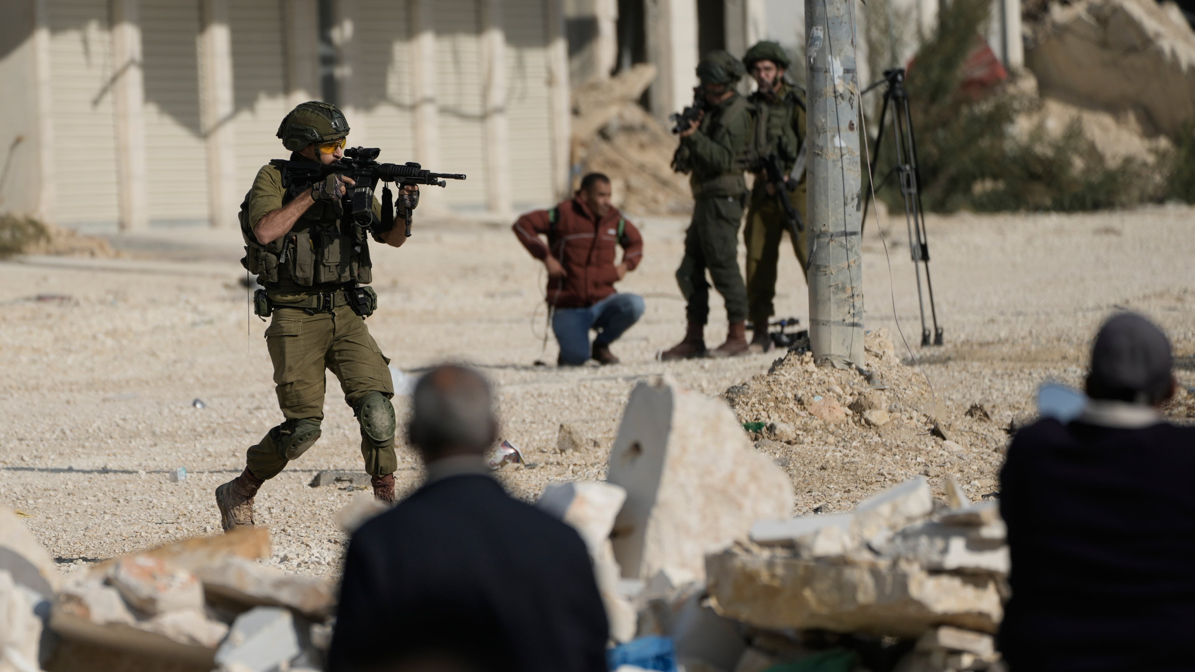 FILE - An Israeli soldier aims his weapon to disperse people taking part in a protest calling for the return of displaced Palestinians to their houses in the Nur Shams refugee camp in the West Bank city of Tulkarem, Nov. 18, 2025. (AP Photo/Majdi Mohammed, File)