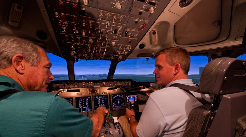 AirTran First Officer Travis Wood is in the right seat (blue shirt) of a Boeing 717 simulator receiving instruction from Captain Robert Wittenberg left seat (green shirt) at AirTran’s training facility in Atlanta on Oct. 7, 2010. Handout photo.