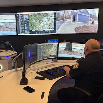 A Chamblee police officer watches surveillance feeds from the department's Real Time Crime Center. Police officials say integrated camera networks help them respond quicker to emergencies. But critics have raised privacy concerns about surveillance technology and what's being done with the data collected. (Shaddi Abusaid/AJC)
