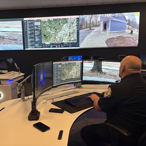 A Chamblee police officer watches surveillance feeds from the department's Real Time Crime Center. Police officials say integrated camera networks help them respond quicker to emergencies. But critics have raised privacy concerns about surveillance technology and what's being done with the data collected. (Shaddi Abusaid/AJC)