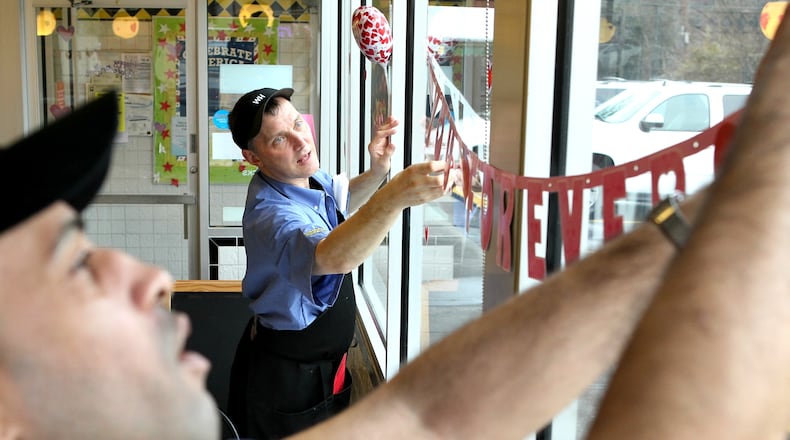 Pratis Boyd, left,  and Eric Hoyle hang Valentine decorations at the Waffle House at Cheshire Bridge Road
 in Atlanta where customers got an opportunity to have a very special
Valentine’s dinner back in 2012.