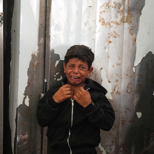 A Palestinian boy cries over the body of Hamouda al-Attar, who was killed by the Israeli army, during his funeral at al-Aqsa Hospital in Deir al-Balah, central Gaza Strip, Saturday, Aug. 29, 2026. (AP Photo/Abdel Kareem Hana)