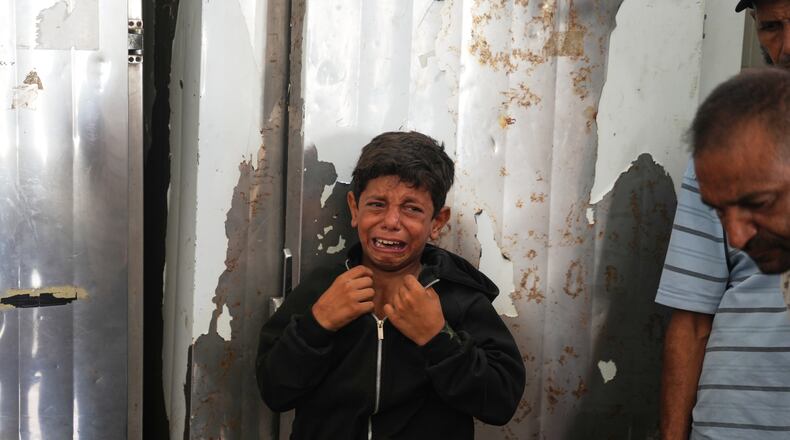 A Palestinian boy cries over the body of Hamouda al-Attar, who was killed by the Israeli army, during his funeral at al-Aqsa Hospital in Deir al-Balah, central Gaza Strip, Saturday, Aug. 29, 2026. (AP Photo/Abdel Kareem Hana)