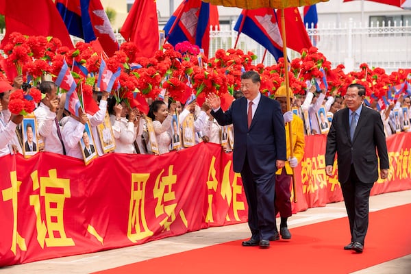 In this photo released by Agence Kampuchea Press (AKP), Chinese President Xi Jingping, left on the carpet, greets the crowd as he is accompanied by Cambodian Senate President Hun Sen, right, during a send-off ceremony at Phnom Penh International Airport in Phnom Penh, Cambodia, Friday, April 18, 2025. (AKP via AP)