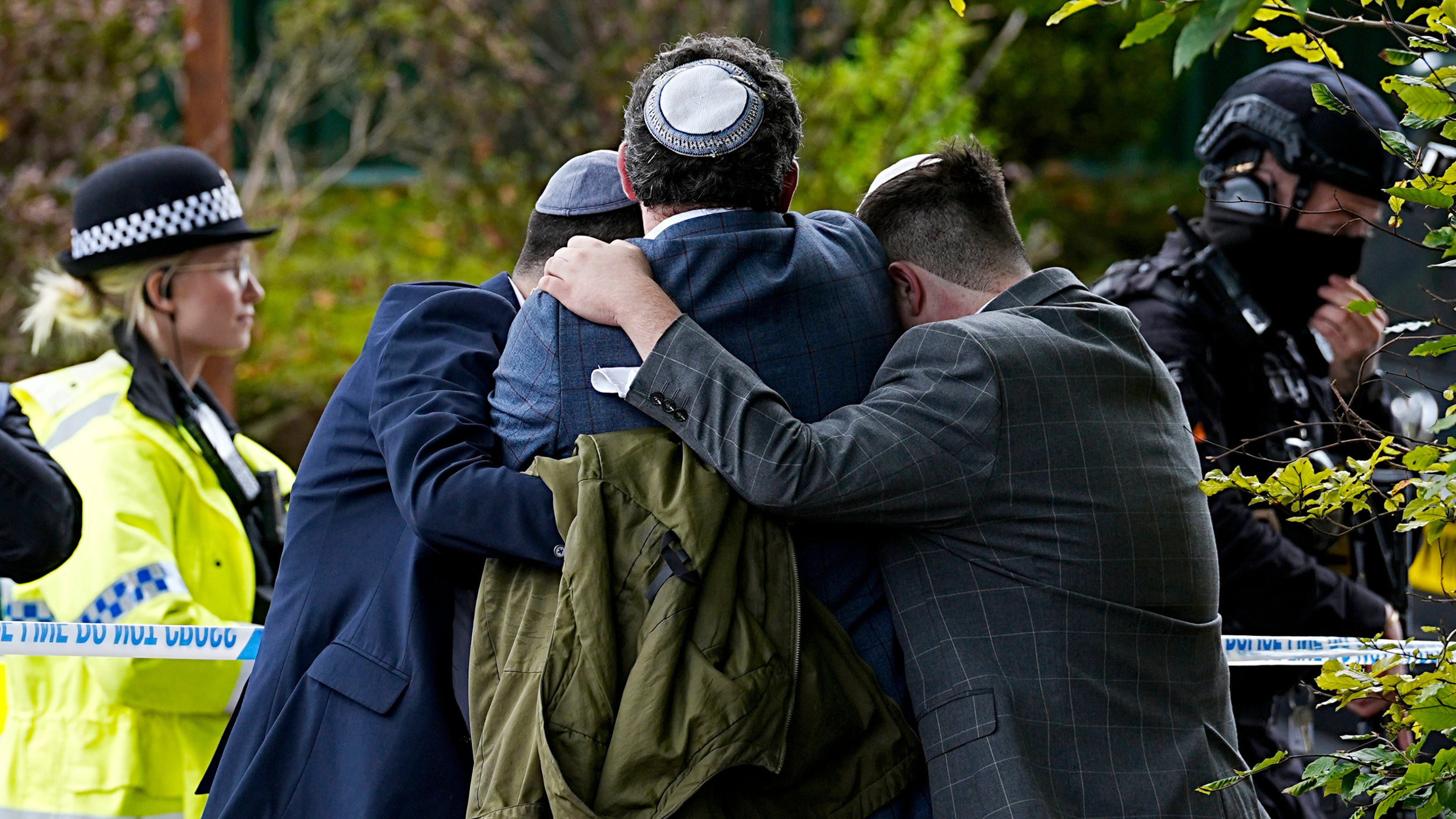 Members of the Jewish community comfort each other near to the Heaton Park Hebrew Congregation synagogue, in Crumpsall, Manchester, England, Thursday, Oct. 2, 2025 after Police reported that two people were killed and three others were seriously injured in a synagogue attack in northern England. (Peter Byrne/PA via AP)