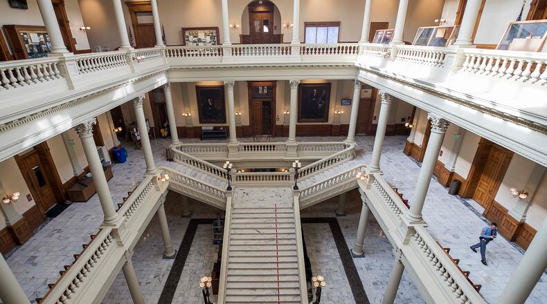 03/13/2020 -- Atlanta, Georgia -- A Georgia State Trooper (right) walks the empty hallways of the Georgia State Capitol building during the 29th day of the Georgia Legislative session, Friday, March 13, 2020. Out of caution and in relation to the coronavirus, the Georgia General General Assembly suspended the legislative session until further notice.  (ALYSSA POINTER/ALYSSA.POINTER@AJC.COM)