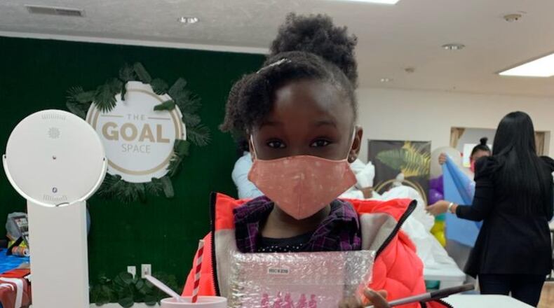 A student who participants in TheraPink for Girls programs poses with the TheraPink journal. Courtesy of TheraPink