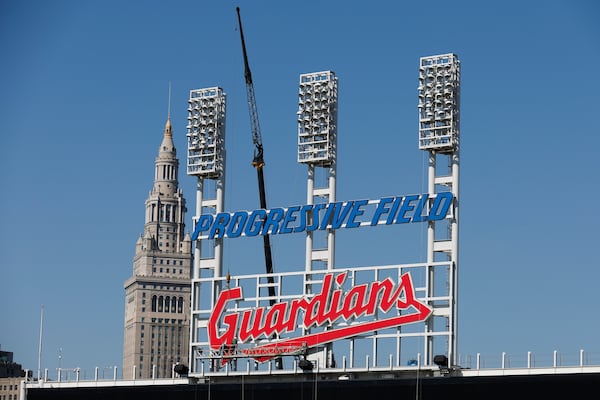 FILE - Workers finish installing the Cleveland Guardians sign above the scoreboard at Progressive Field, March 17, 2022, in Cleveland. (AP Photo/Ron Schwane, file)