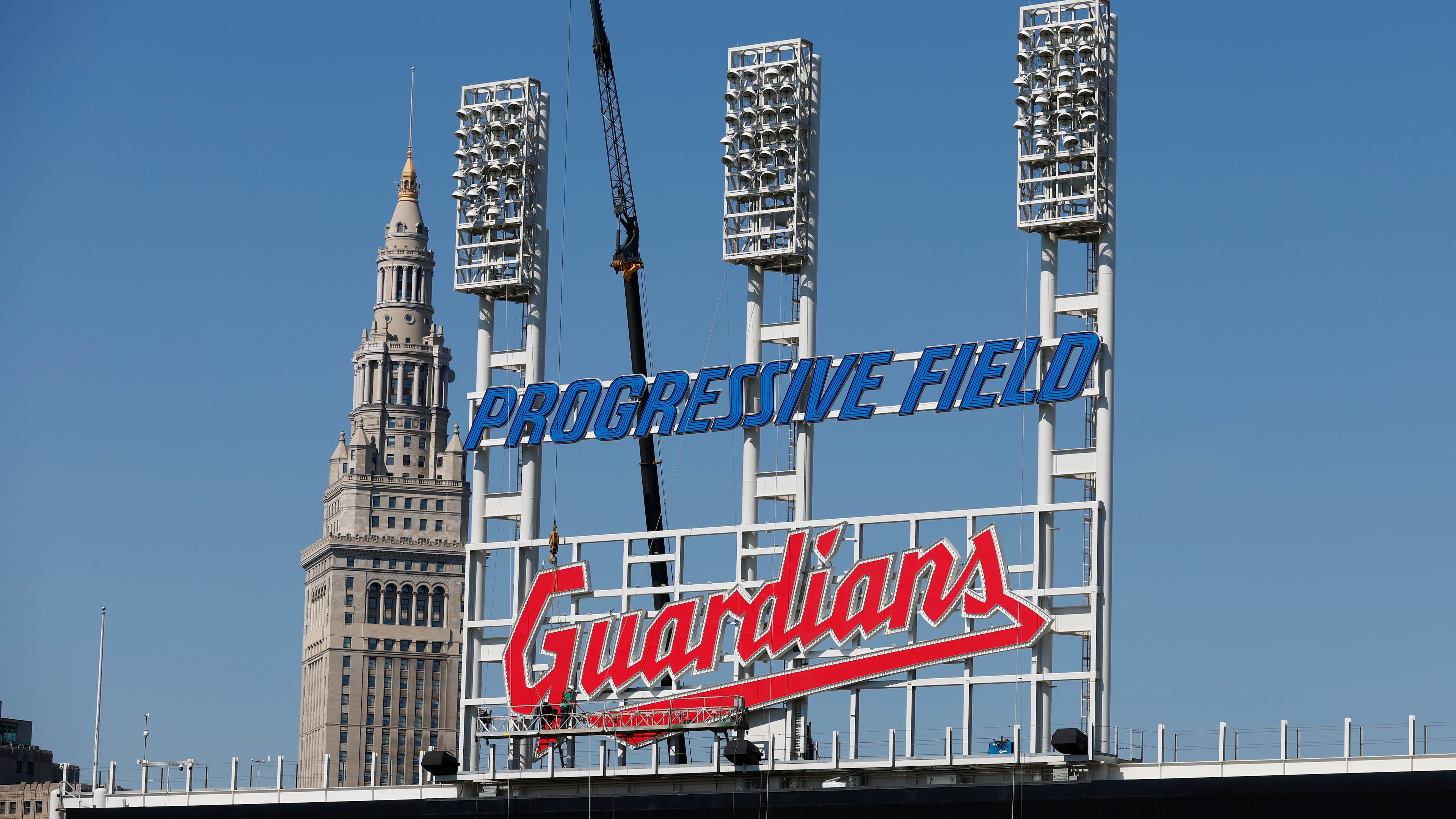 FILE - Workers finish installing the Cleveland Guardians sign above the scoreboard at Progressive Field, March 17, 2022, in Cleveland. (AP Photo/Ron Schwane, file)