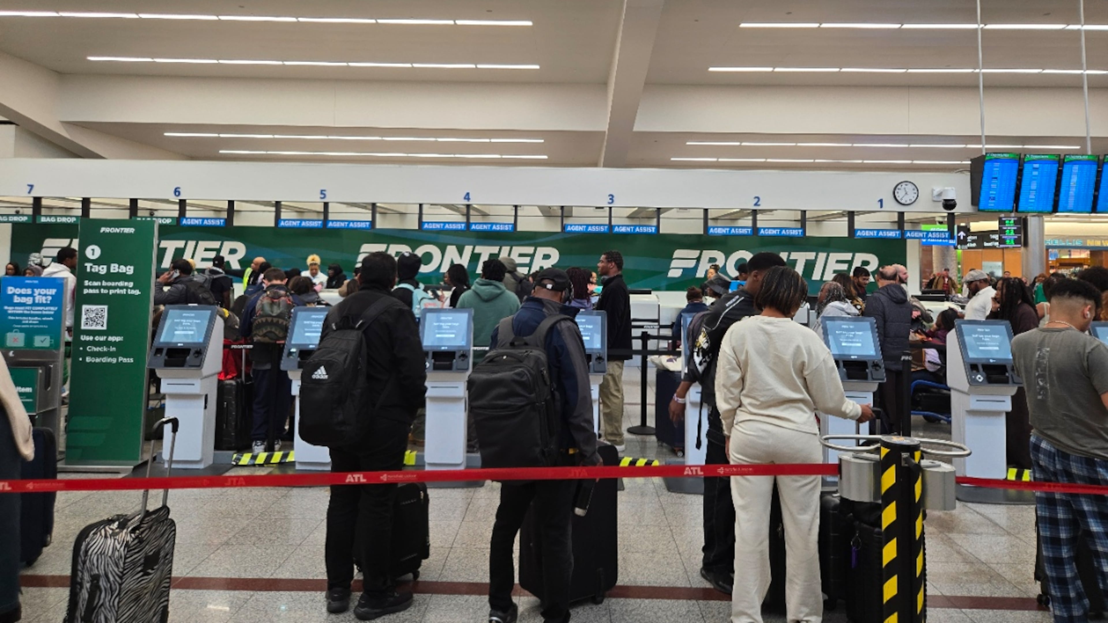 Passengers wait to check in or drop off luggage at the Frontier Airlines counter around lunchtime Sunday, Nov. 30, 2025. More than 100,000 travelers were expected to fly out of Hartsfield-Jackson Atlanta International Airport on Sunday. (Maya T. Prabhu/AJC)