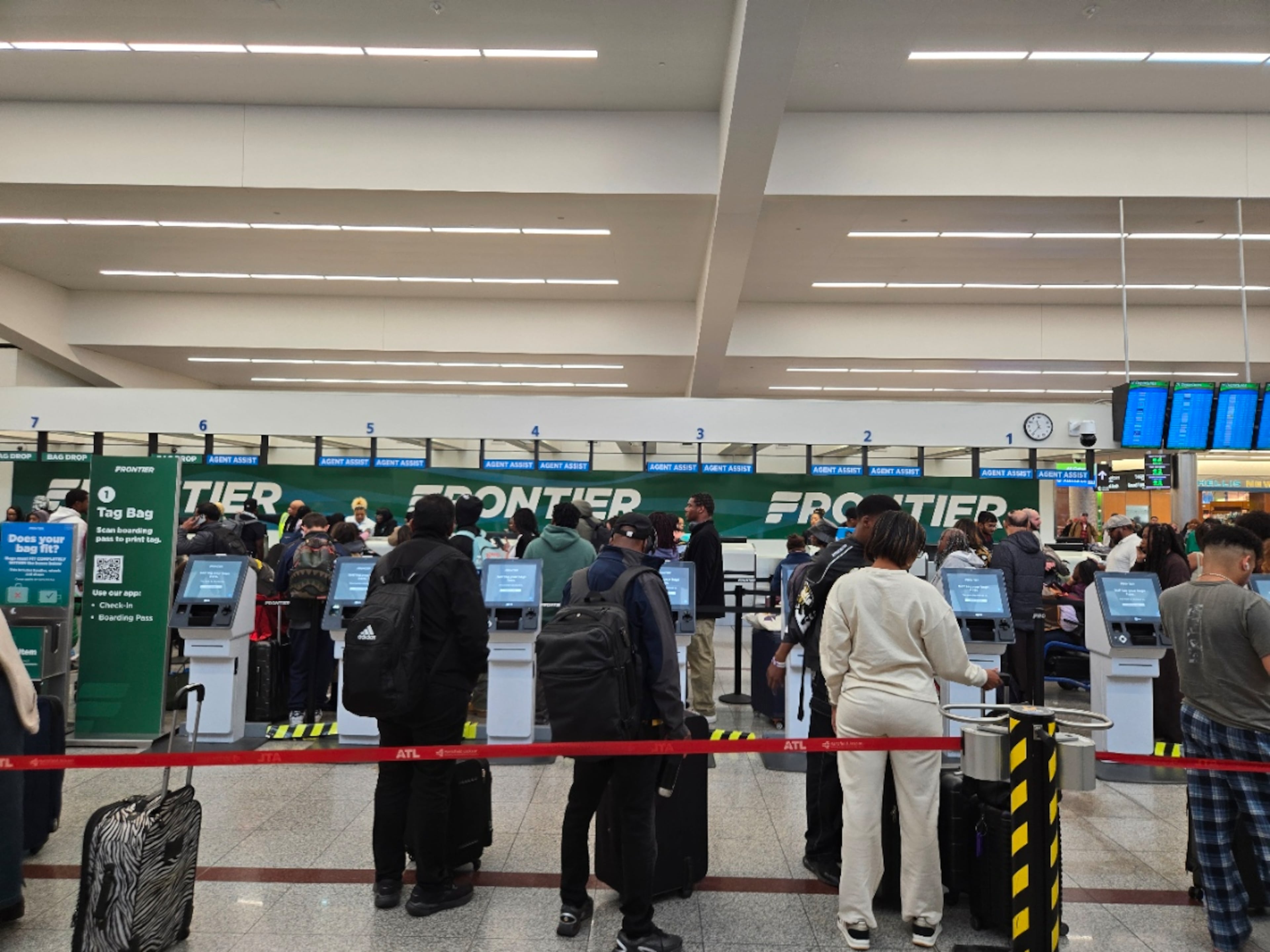 Passengers wait to check in or drop luggage at the Frontier Airlines counter around lunchtime Sunday, Nov. 30, 2025. More than 100,000 travelers were expected to fly out of Hartsfield-Jackson Atlanta International Airport on Sunday. (Maya T. Prabhu/AJC)