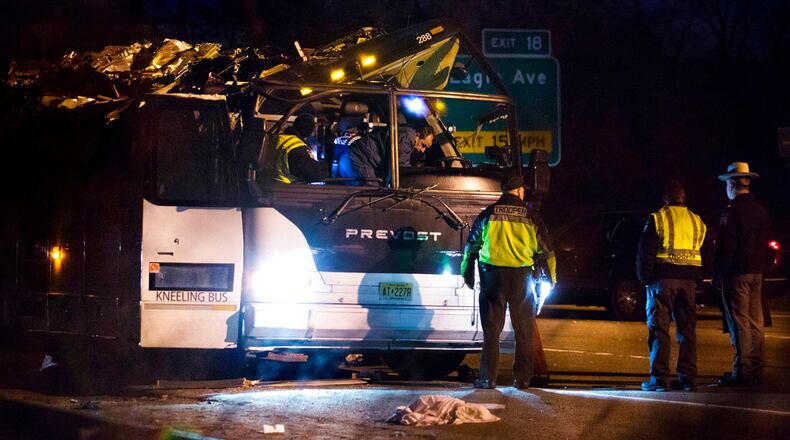 A bus that was carrying teenage passengers sits on the side of a highway after it hit an overpass on the Southern State Parkway in Lakeview, N.Y., Monday, April 9, 2018. The charter bus carrying teenagers returning from a spring break trip struck a bridge overpass on Long island, seriously injuring several passengers and mangling the entire length of the top of the bus. (AP Photo/Kevin Hagen)