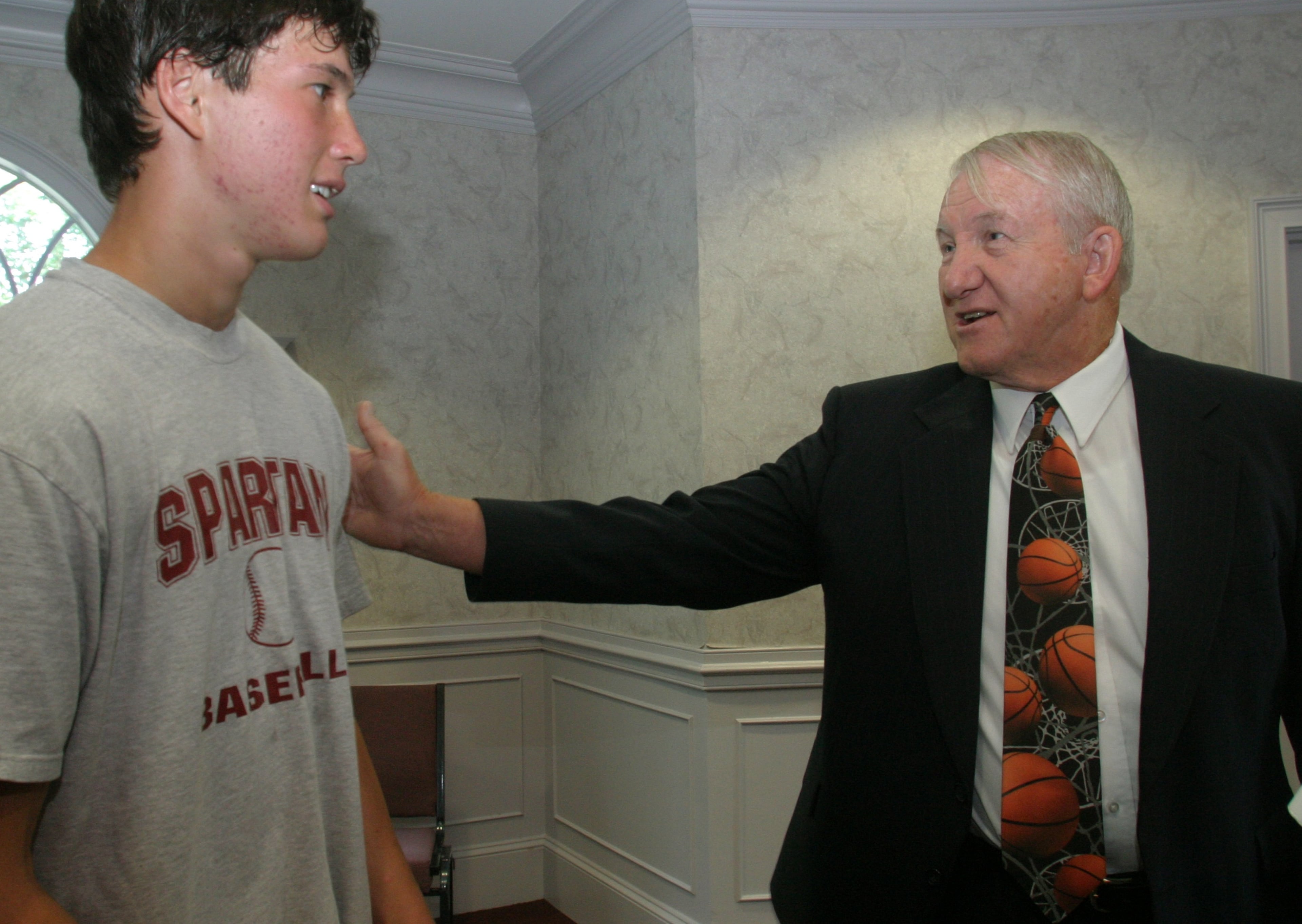 In this file photo, Ronald Bradley, new boys basketball coach at Greater Atlanta Christian, talks with a student and potential basketball player, Justin Schneider, then 16, after a press conference at GAC on Friday, June 24, 2005. (Jessica McGowan/Special)