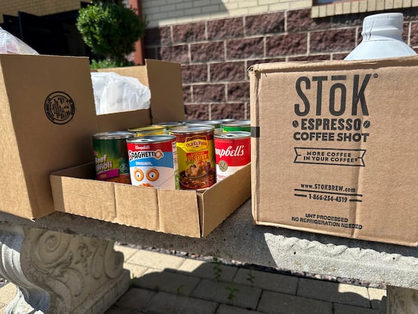 Cans and boxes of food sit on a bench outside the Samaritan Center food pantry in Jefferson City, Mo., on Tuesday, July 1, 2025. (AP Photo/David A. Lieb)