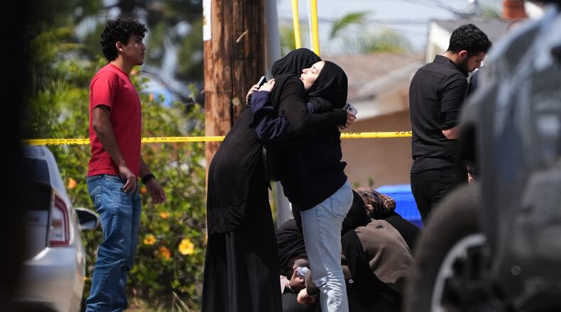 People embrace near the scene of a shooting outside the Islamic Center of San Diego Monday, May 18, 2026, in San Diego. (AP Photo/Gregory Bull)