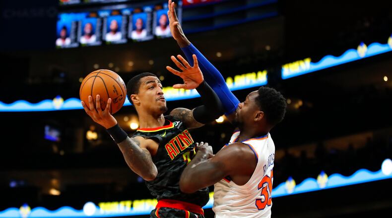 Atlanta Hawks forward John Collins (left) goes up to shoot as New York Knicks forward Julius Randle (30) defends in the first half Sunday, Feb. 9, 2020, at State Farm Arena in Atlanta.