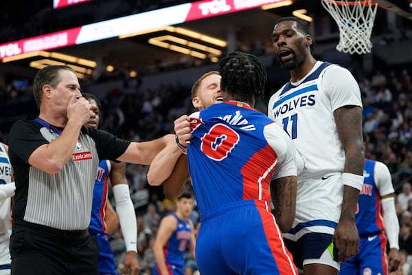 Minnesota Timberwolves guard Donte DiVincenzo (0), center back, Timberwolves center Naz Reid (11) and Detroit Pistons center Jalen Duren (0) get into an altercation during the first half of an NBA basketball game, Sunday, March 30, 2025, in Minneapolis. (AP Photo/Abbie Parr)
