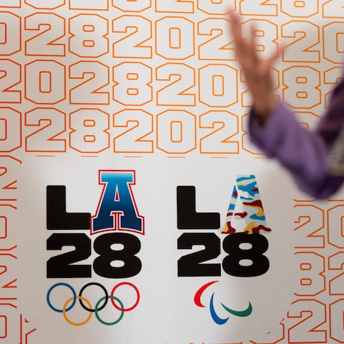 FILE - LA28 logos decorate a backdrop as First lady Jill Biden speaks at a reception at the U.S. Chief of Mission Residence to commemorate the opening of the 2024 Summer Olympics and celebrate the upcoming 2028 Olympic Games, to be held in Los Angeles, Saturday, July 27, 2024, in Paris. (AP Photo/David Goldman, File)