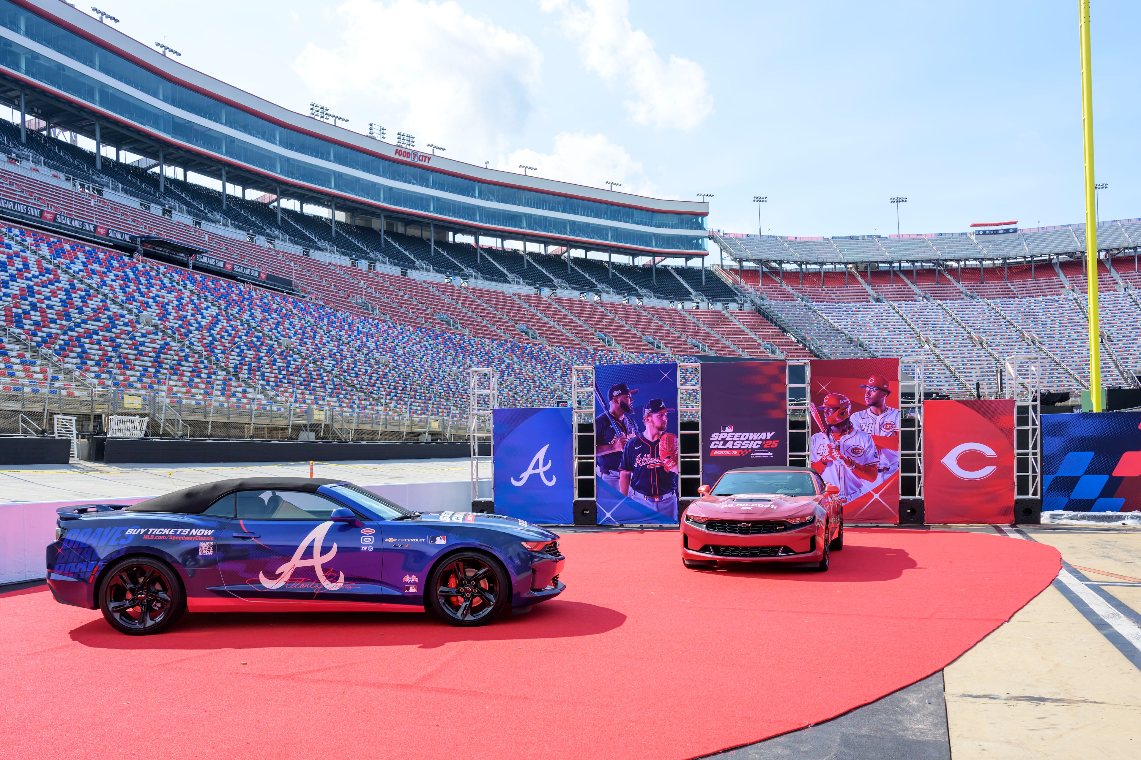 Atlanta Braves (left) and Cincinnati Reds themed race cars are displayed at Bristol Motor Speedway, Thursday, July 31, 2025, in Bristol, Tennessee, as preparations continue for the MLB Speedway Classic baseball game between the two teams on Aug. 2. (Earl Neikirk/Bristol Motor Speedway via AP)