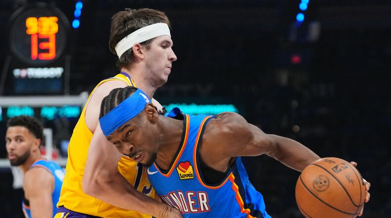 Oklahoma City Thunder guard Shai Gilgeous-Alexander, right, drives to the basket as Los Angeles Lakers guard Austin Reaves, left, defends second half of Game 1 in a second-round NBA basketball playoffs series Tuesday, May 5, 2026 in Oklahoma City. (AP Photo/Kyle Phillips)