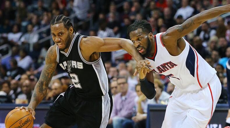 Spurs forward Kawhi Leonard drives against Hawks forward DeMarre Carroll during a game earlier this season in Atlanta. Curtis Compton / ccompton@ajc.com