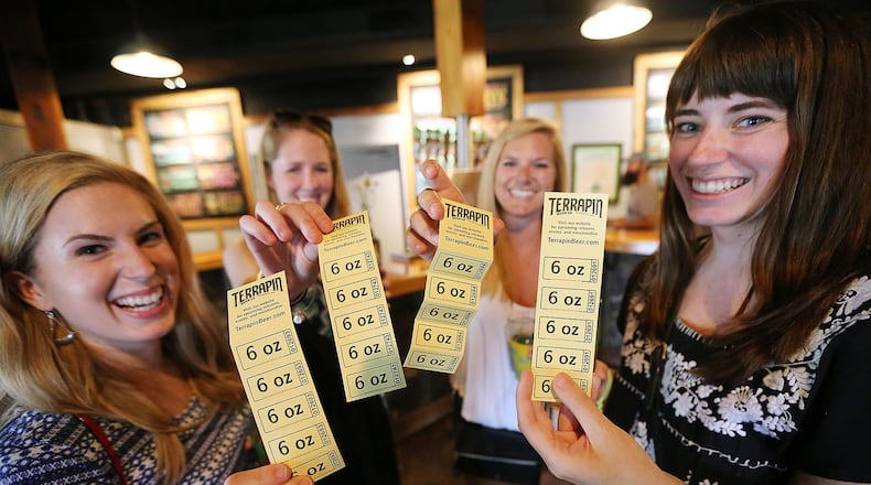 Maggie Carter (from left), Kyle Hopwood, Angela Denicolo and Ashley Westpheling show off tickets for beer samples in the tasting room at the Terrapin Beer Company that are part of the tour option they purchased in August. Curtis Compton / ccompton@ajc.com