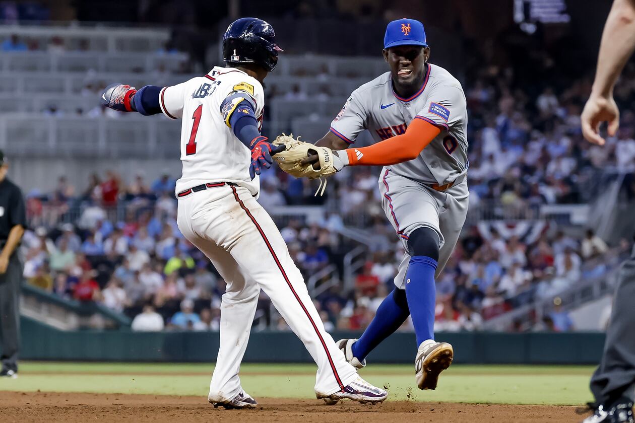 New York Mets shortstop Ronny Mauricio, right, tags out Atlanta Braves' Ozzie Albies, left, between second base and third during the fifth inning of a baseball game, Monday, July 6, 2026, in Atlanta. (AP Photo/Erik S. Lesser)
