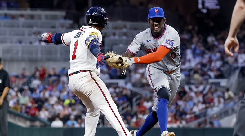 New York Mets shortstop Ronny Mauricio, right, tags out Atlanta Braves' Ozzie Albies, left, between second base and third during the fifth inning of a baseball game, Monday, July 6, 2026, in Atlanta. (AP Photo/Erik S. Lesser)