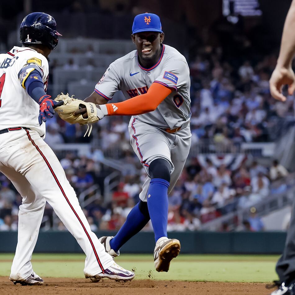 New York Mets shortstop Ronny Mauricio, right, tags out Atlanta Braves' Ozzie Albies, left, between second base and third during the fifth inning of a baseball game, Monday, July 6, 2026, in Atlanta. (AP Photo/Erik S. Lesser)