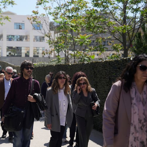 People leave a courthouse after a gunman opened fire leaving several people wounded in Athens, Tuesday, April 28, 2026. (AP Photo/Petros Giannakouris)