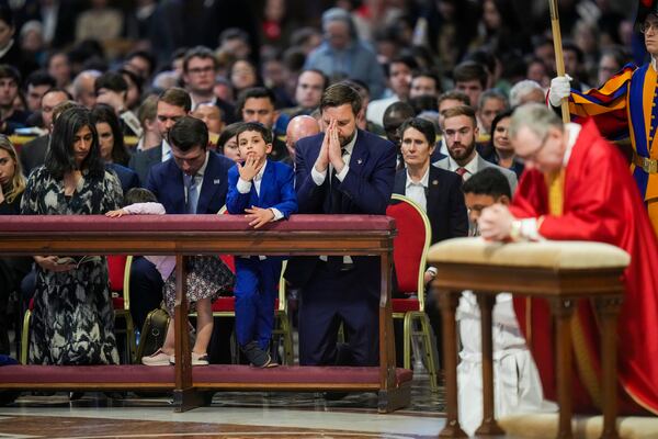 U.S. Vice President JD Vance, and his wife Usha Vance, left, with their daughter Mirabel, partially hidden, and son Vivek attend a Good Friday service led by Cardinal Claudio Gugerotti, right, inside St. Peter's Basilica at the Vatican, Friday, April 18, 2025. (AP Photo/Alessandra Tarantino)