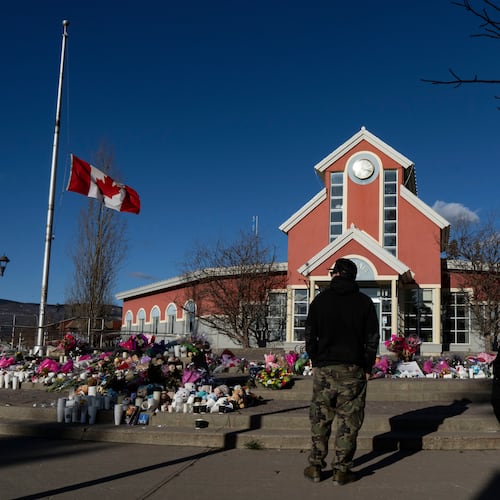 FILE - People pay their respects at a memorial on the steps of the Town Hall following a vigil the previous day in Tumbler Ridge, B.C., Saturday, Feb. 14, 2026. (Christinne Muschi/The Canadian Press via AP, file)