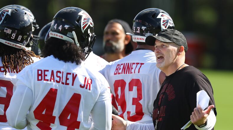 July 22, 2019 Flowery Branch: Falcons head coach Dan Quinn works with Vic Beasley Jr. on his defense after a play during the first practice at training camp on Monday, July 22, 2019, in Flowery Branch. Curtis Compton/ccompton@ajc.com