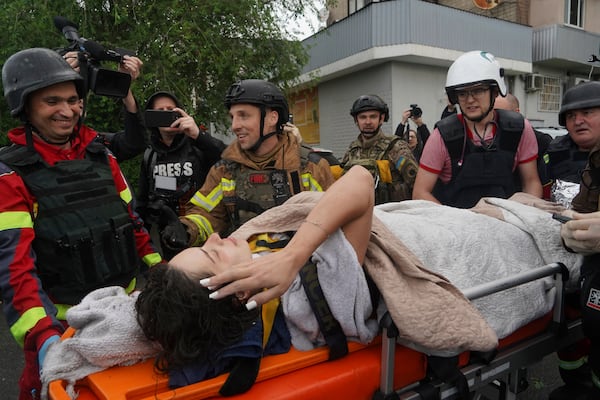 Rescuers carry a wounded woman after Russian attack that hit a residential building in Kharkiv, Ukraine, Saturday, June 7, 2025. (AP Photo/Andrii Marienko)