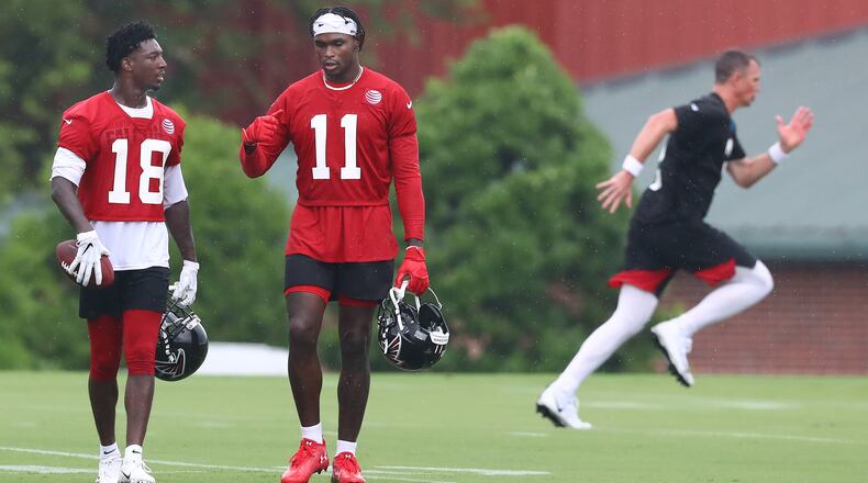 Falcons quarterback Matt Ryan (background) runs some sprints after getting in some extra work with wide receivers Calvin Ridley (left) and Julio Jones after the second day of practice at training camp Tuesday, July 23, 2019, in Flowery Branch.
