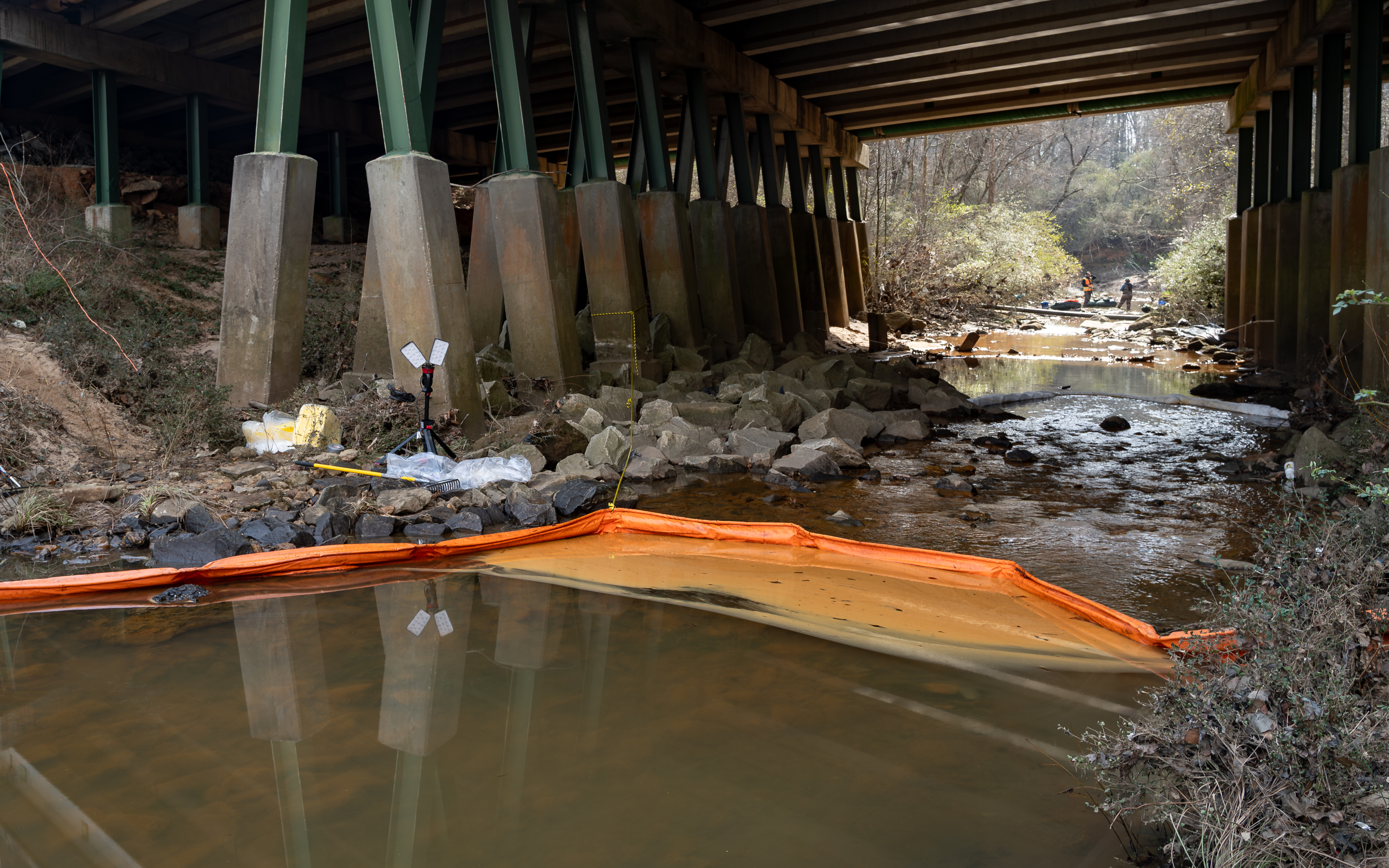 What appears to be oil pools along a containment boom deployed following a fuel spill into the Flint River south of Hartsfield-Jackson International Airport on Tuesday, Feb 03, 2026. (Ben Hendren for the AJC)