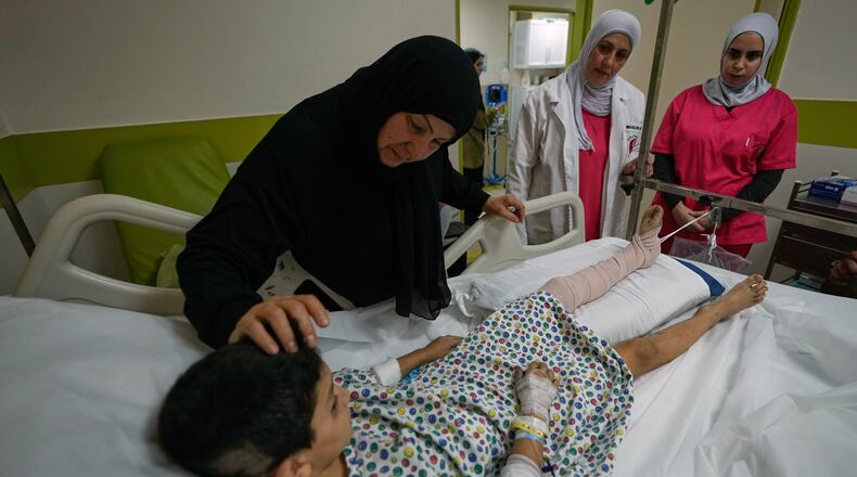 Mustafa Farhat, 8, who was injured in an Israeli airstrike that hit his home and killed his parents, is comforted by his grandmother at a hospital in the town of Nabatiyeh, southern Lebanon, Monday, Sept. 7, 2026. (AP Photo/Mohammed Zaatari)
