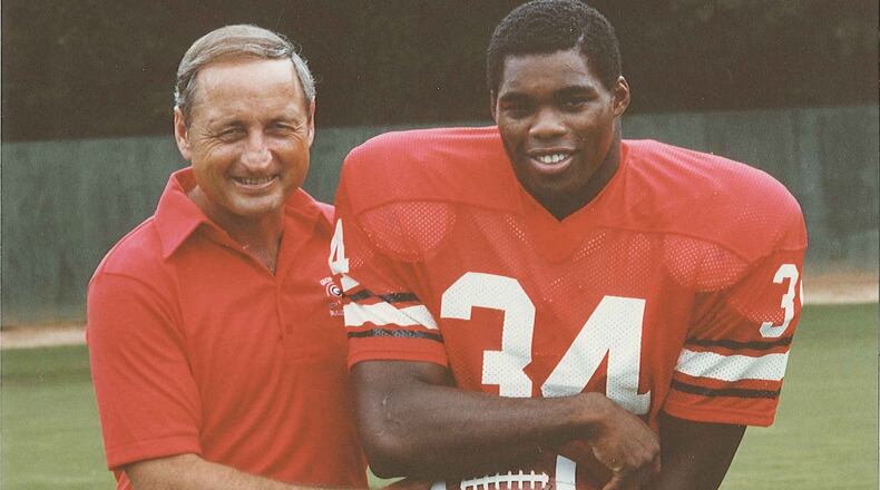 Georgia coach Vince Dooley hands the ball off to freshman tailback Herschel Walker in a posed photo from the 1980 season. (Photo provided by UGA Athletics)