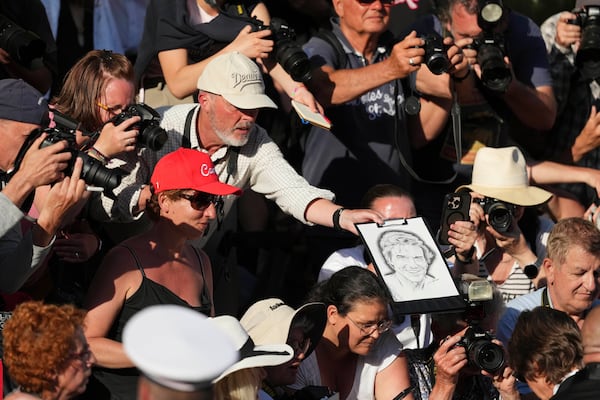 Tom Cruise, bottom right, signs autographs upon arrival for the premiere of the film 'Mission: Impossible - The Final Reckoning' at the 78th international film festival, Cannes, southern France, Wednesday, May 14, 2025. (Photo by Lewis Joly/Invision/AP)