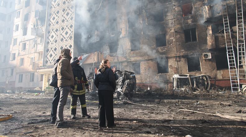 People look at a residential building which was heavily damaged after a Russian strike on Ternopil, Ukraine, on Wednesday, Nov. 19, 2025. (AP Photo/Vlad Kravchuk)