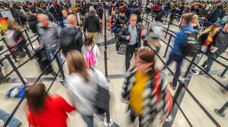 Travelers make their way through the security check point at Hartsfield-Jackson International Airport. JOHN SPINK/JSPINK@AJC.COM