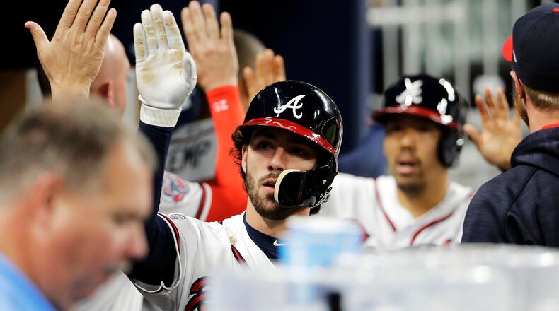 Braves’ Dansby Swanson, left, and Kurt Suzuki high-five teammates after scoring off a single by Ender Inciarte in the fourth inning. (AP Photo/David Goldman)