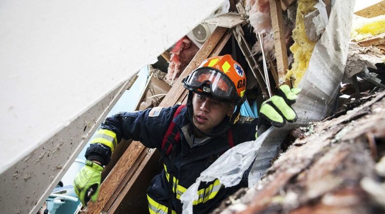 A rescue worker searches inside a mobile home Monday in Albany. (Credit: Branden Camp / Associated Press)