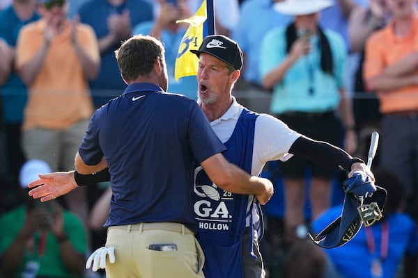 Scottie Scheffler hugs his caddie Ted Scott after winning the PGA Championship golf tournament at the Quail Hollow Club, Sunday, May 18, 2025, in Charlotte, N.C. (AP Photo/David J. Phillip)