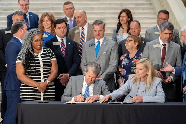 Gov. Brian Kemp signs House Bill 463 inside the Georgia Capitol building on Monday. (Ben Hendren for the AJC)