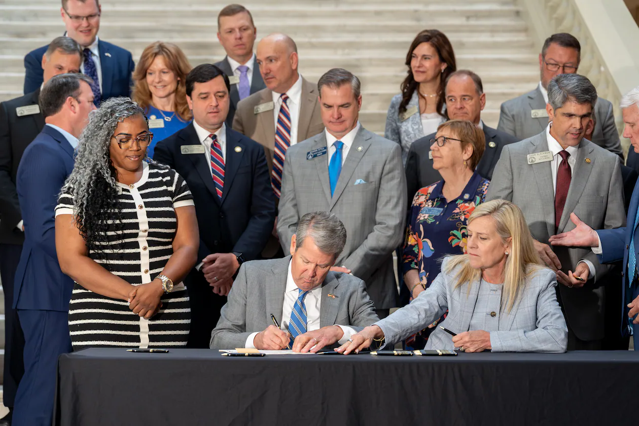 Gov. Brian Kemp signs House Bill 463 on Monday. The law cuts the state income tax rate. (Ben Hendren for the AJC)