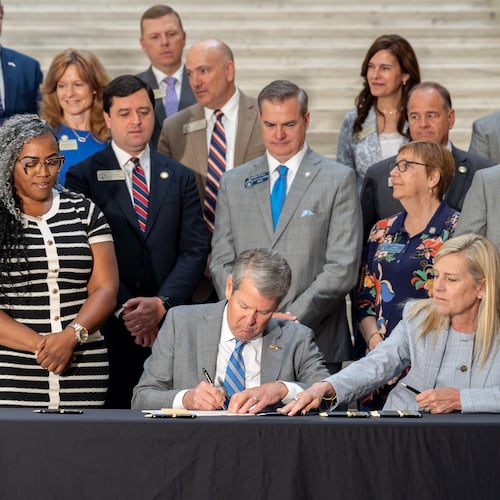 Gov. Brian Kemp signs House Bill 463 on Monday. The law cuts the state income tax rate. (Ben Hendren for the AJC)
