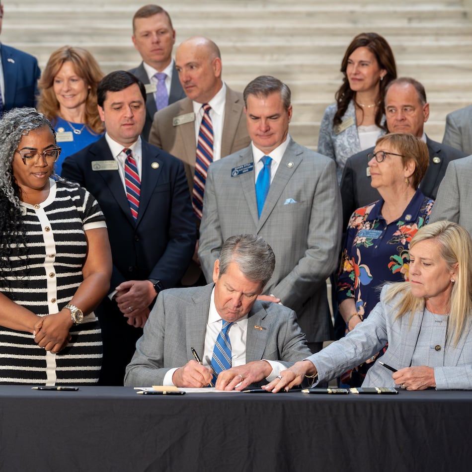 Gov. Brian Kemp signs House Bill 463 on Monday. The law cuts the state income tax rate. (Ben Hendren for the AJC)