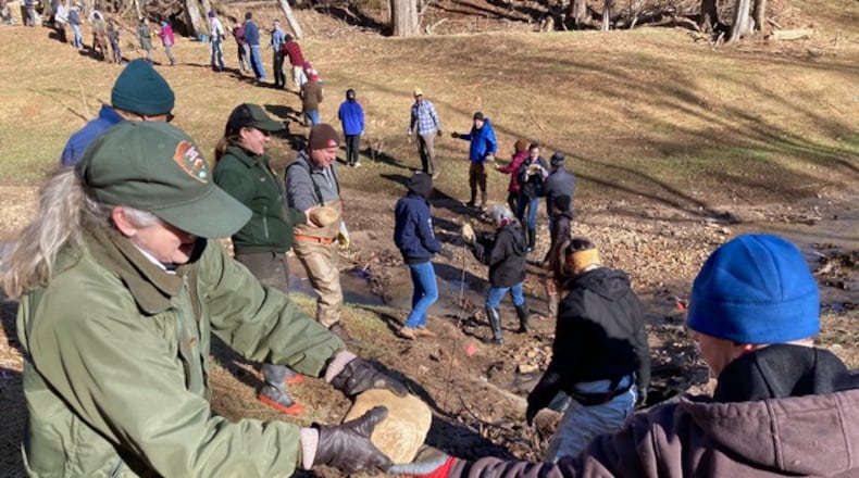 Volunteers gathered in February at Crayfish Creek in Sugar Hill to extend stabilization efforts into the creek with stones, boulders and huge logs that will also serve as habitat for aquatic wildlife. (Courtesy Tixie Fowler, Gwinnett County Soil and Water Conservation District)